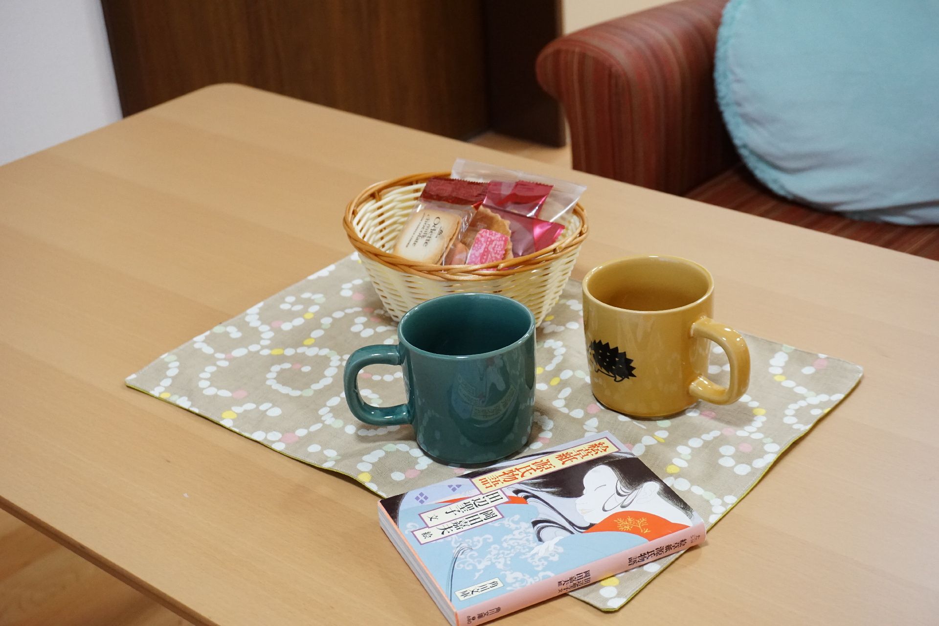 テーブルに置かれてたマグカップとかごに入ったお菓子
