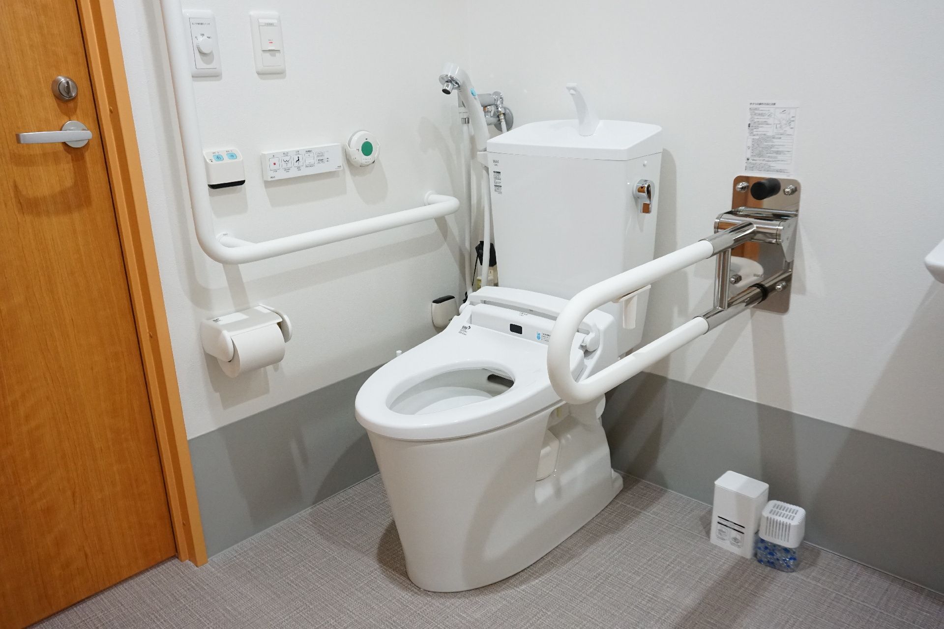 トイレの便座にふたはなく、手すりが両サイドに付いている