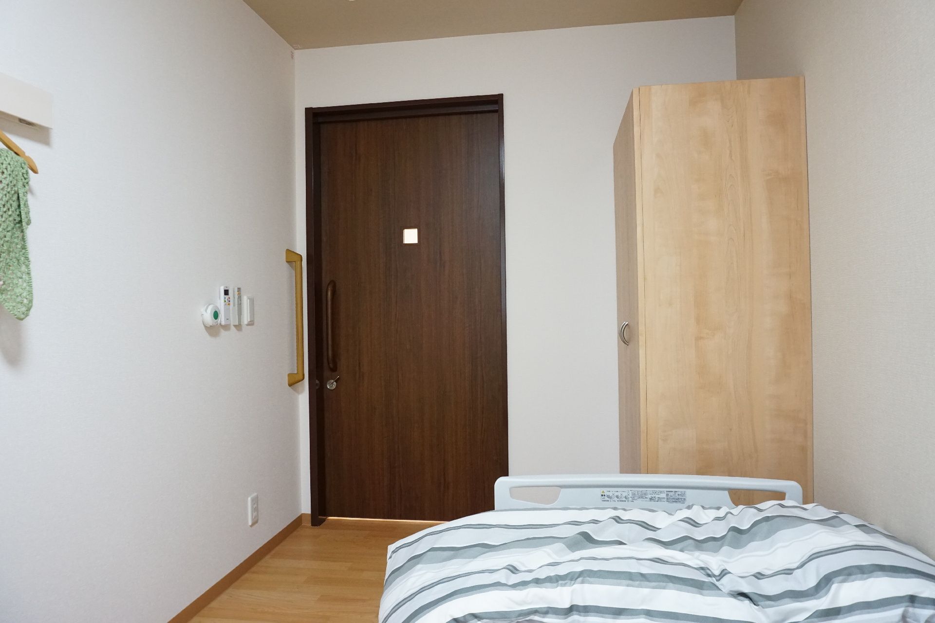 フローリングの部屋には寝具付きのベッドやタンスなどが置かれている。