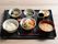 ご飯とおかず類が数種類置かれているお盆の写真。施設内で出されるメニューの一例