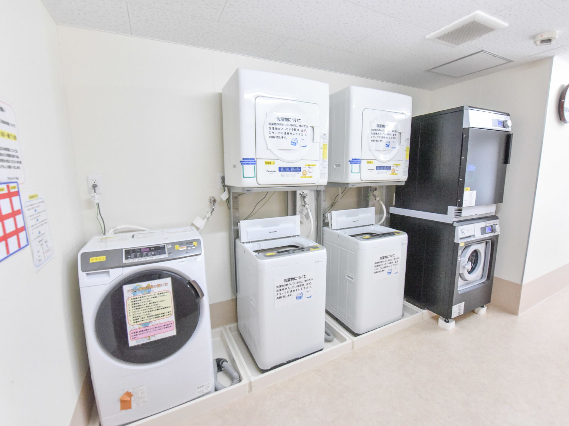 洗濯機には使い方や注意書きが明記されている。洗濯機も乾燥機も大型なので一度に大量の衣類を洗濯できる。