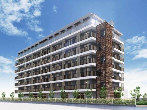 7階建ての建物は重厚感がある大きな建物で、周りには木がたくさん植えられている。側面には屋外階段があり、ベランダも付いている。
