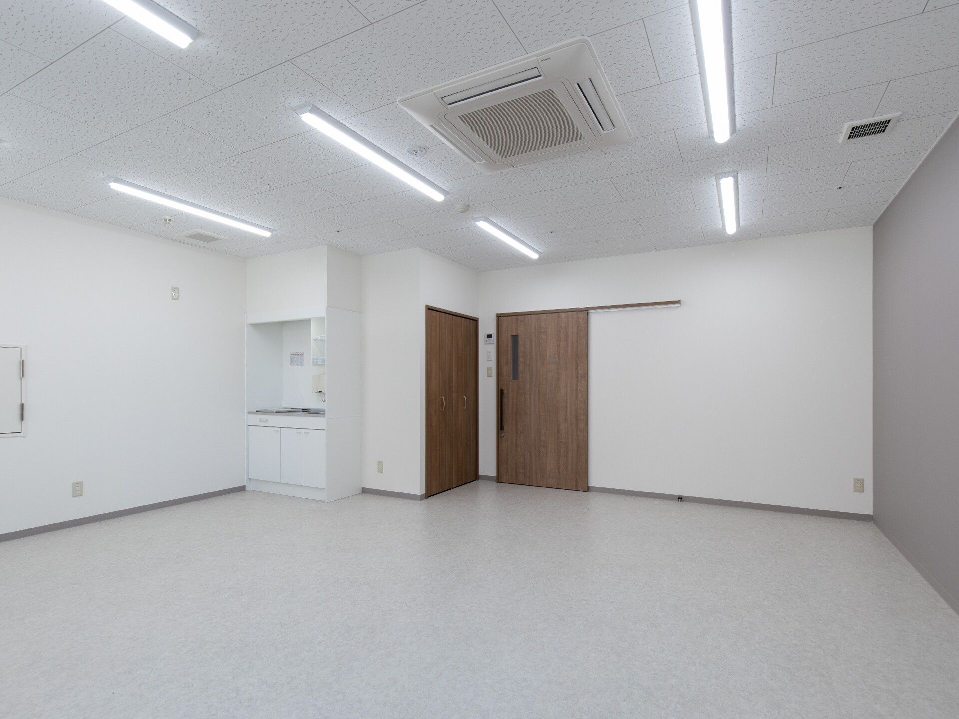 ミニキッチンが設置されている白を基調とした部屋には家具などは置かれていない。