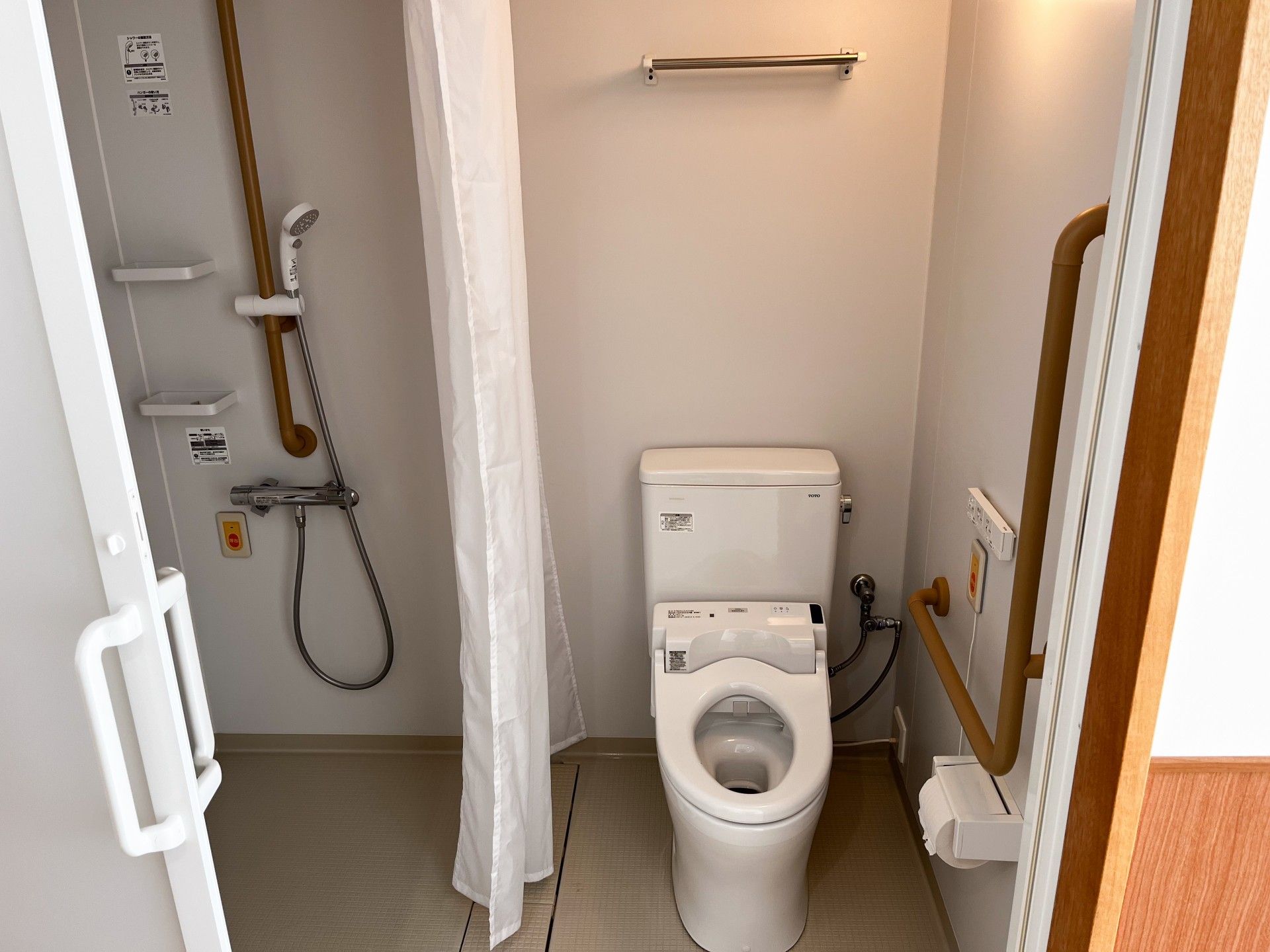 手すり付きのトイレとシャワー