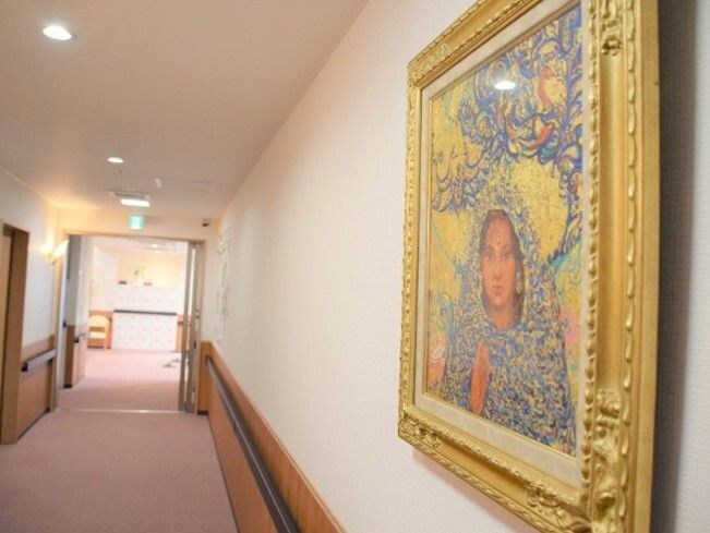 金の額縁に入った女性の絵が飾られた廊下は両サイドに手すりが付き、幅の広いまっすぐな造りとなっている。