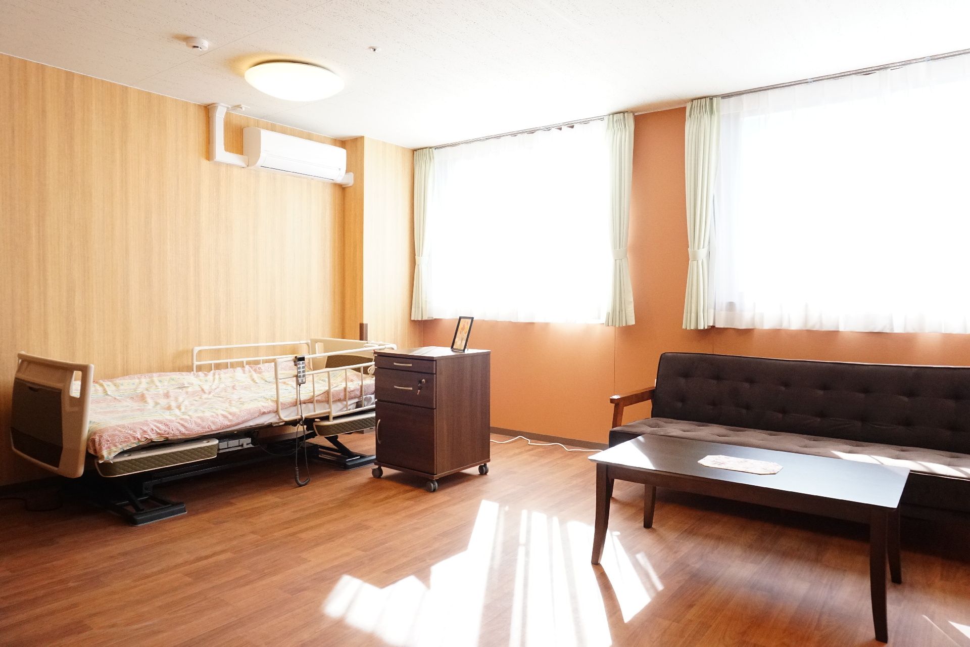 大きな窓が取り付けられ、介護ベッドが設置されている居室