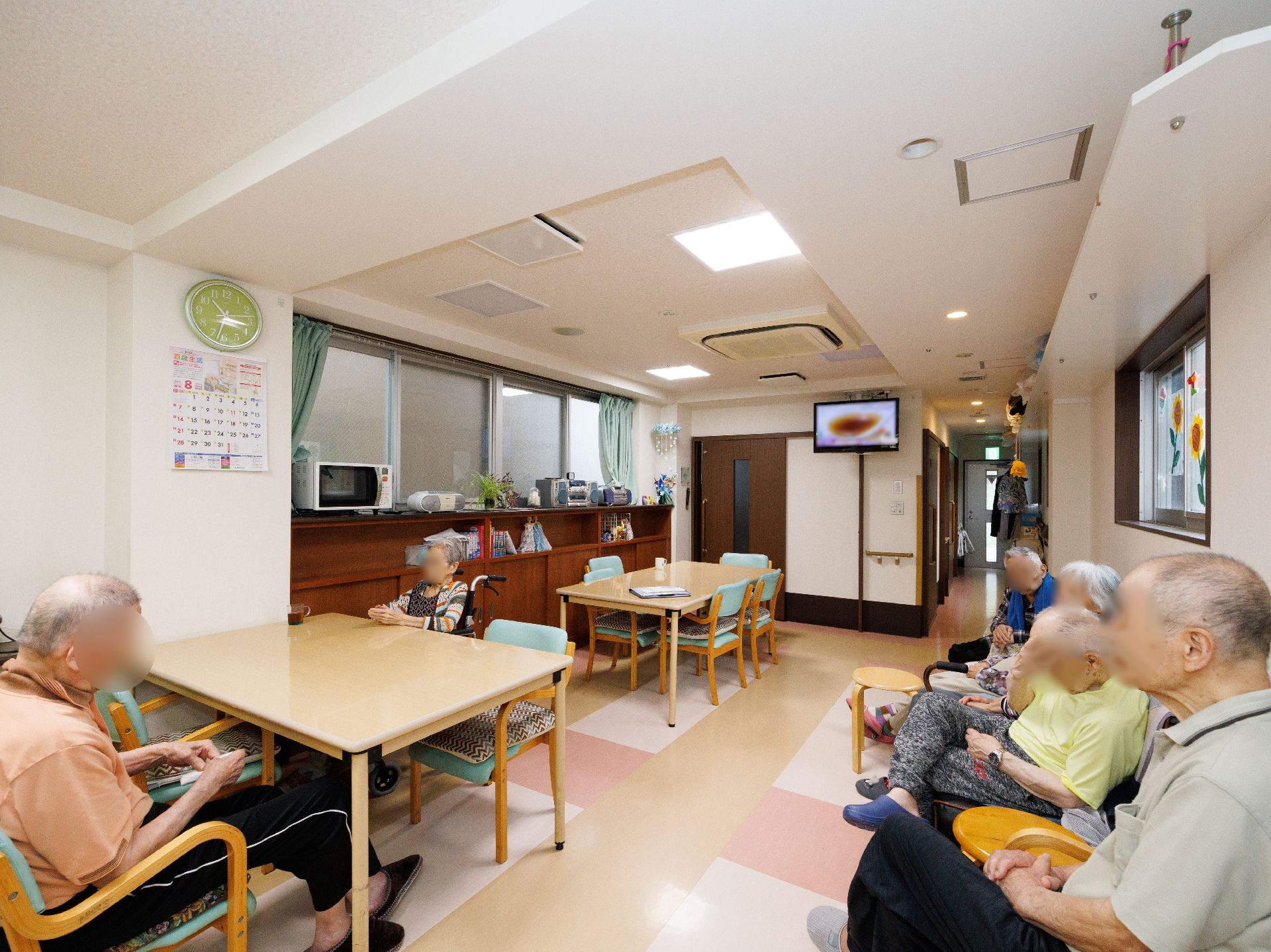 テレビが設置され、テーブルや椅子が多く置かれている共有スペース
