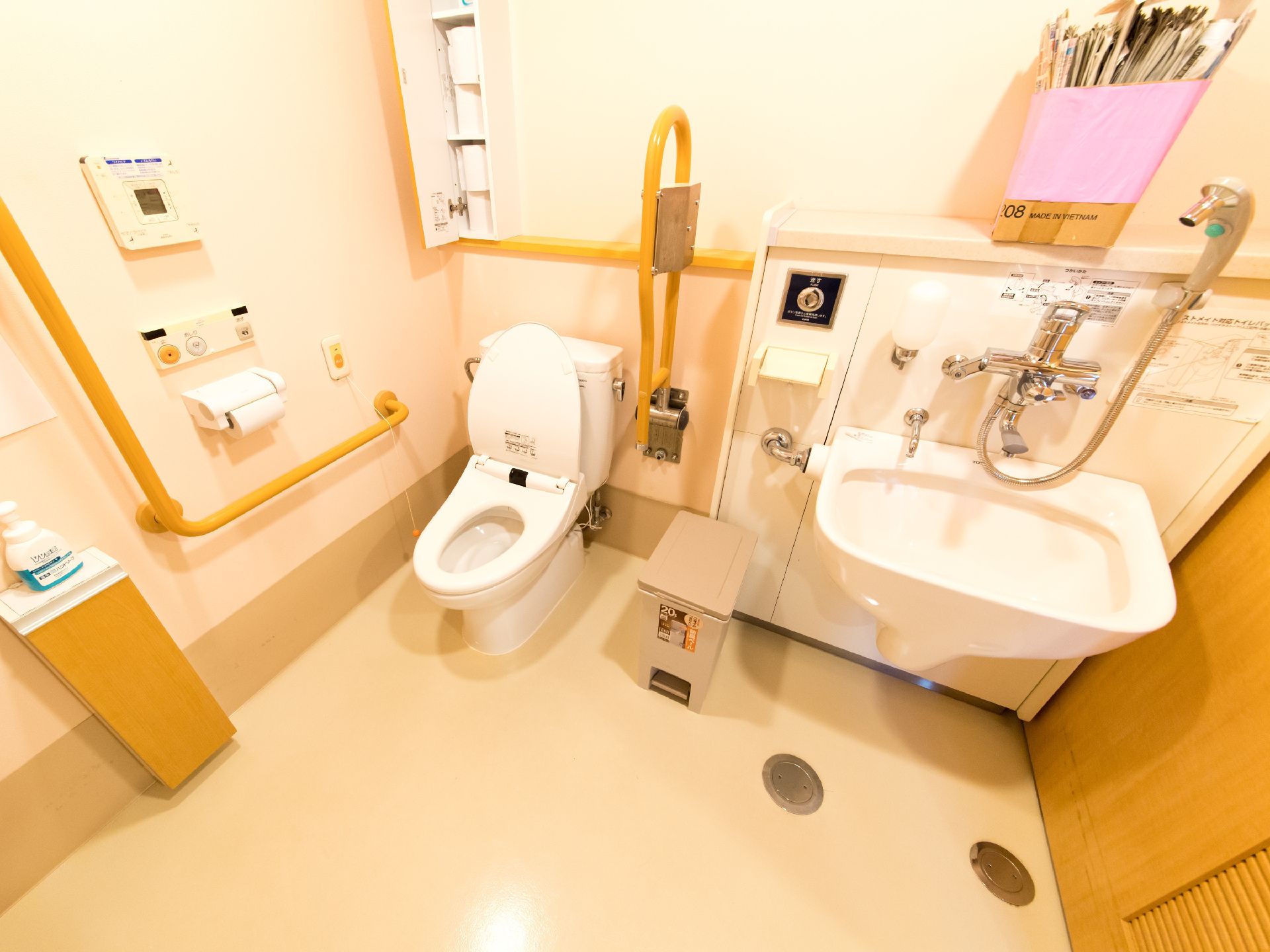 トイレの壁に作り付けの棚がありトイレットペーパーの予備が保管されている。体調急変時に職員を呼び出すボタンが設置されている。