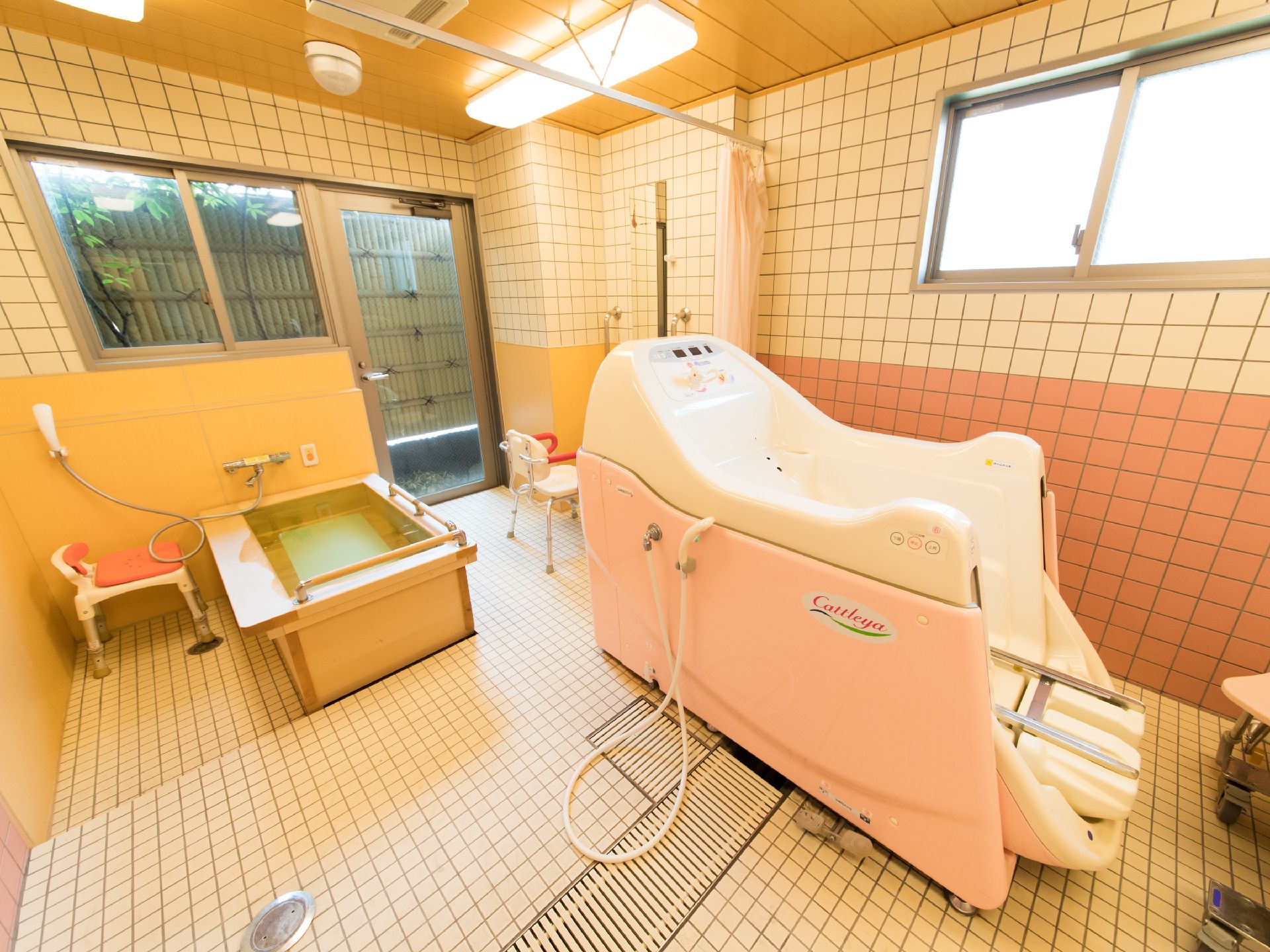 腰などに負担がかからないように、浴槽の淵に手すりがついた湯船があり、その付近の壁に緊急時用のブザーが取り付けてある。