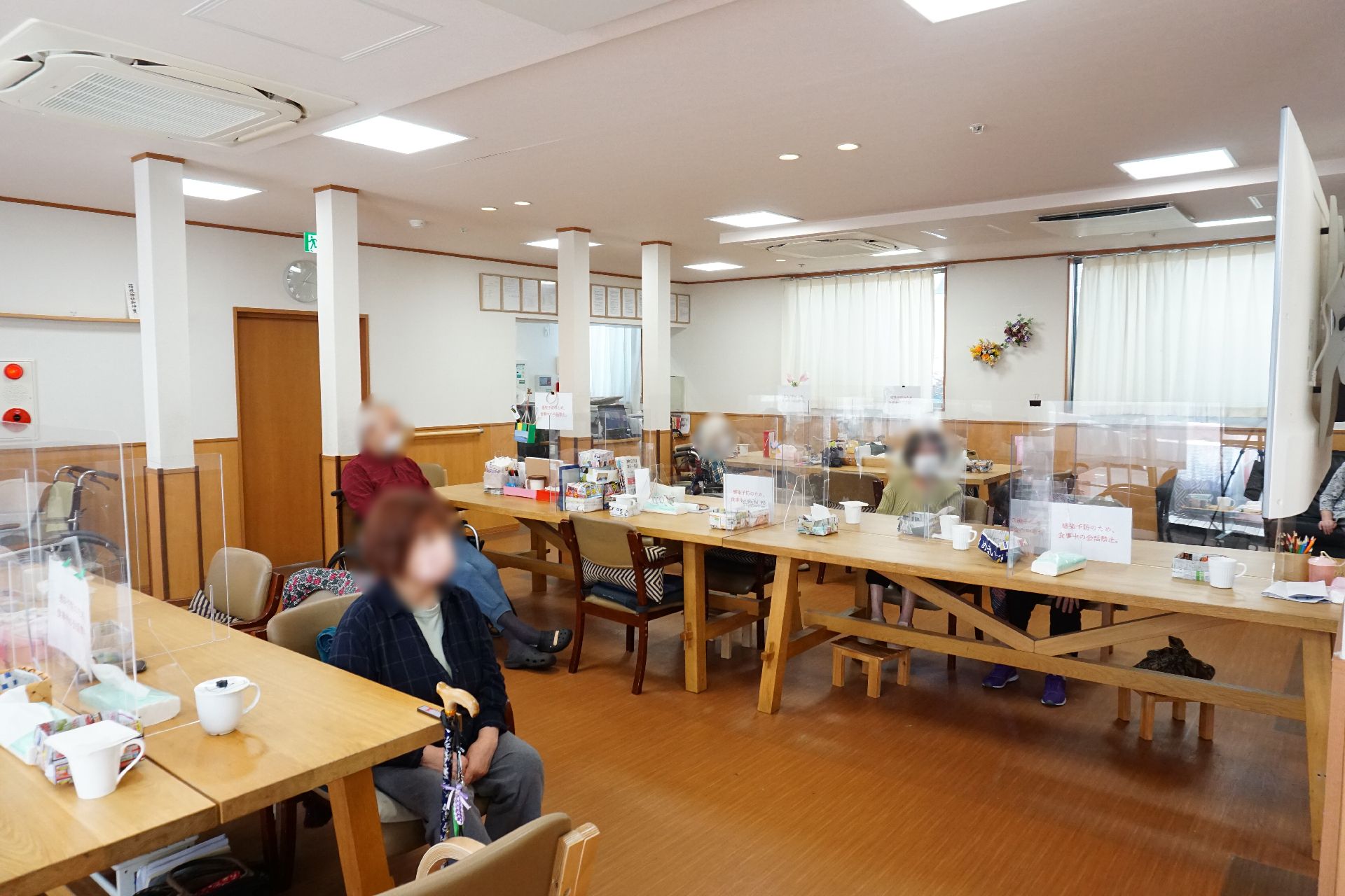 車いすに乗った女性を押す家族の男性とそこに寄り添う介護スタッフの様子