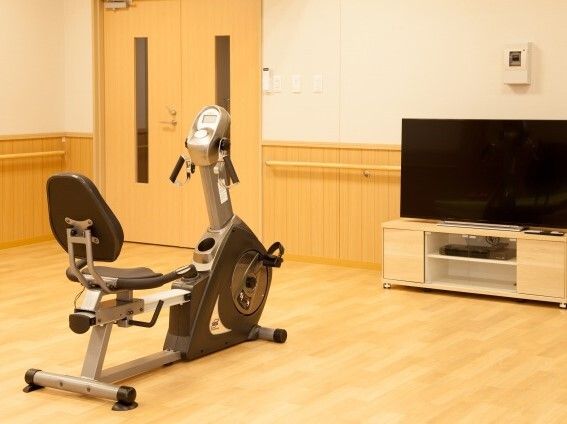 バイクマシンが大きなテレビを正面から見ることができる位置に置かれている。他にマシンはない。