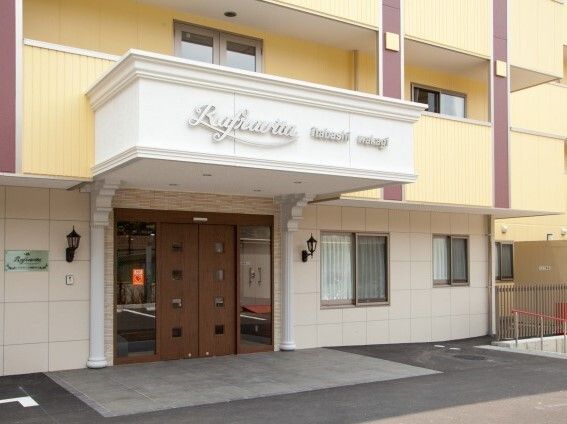 周りには高い建物がなく、上空には青空が広がっている。ベージュ系の外壁の建物はどっしりとした雰囲気。
