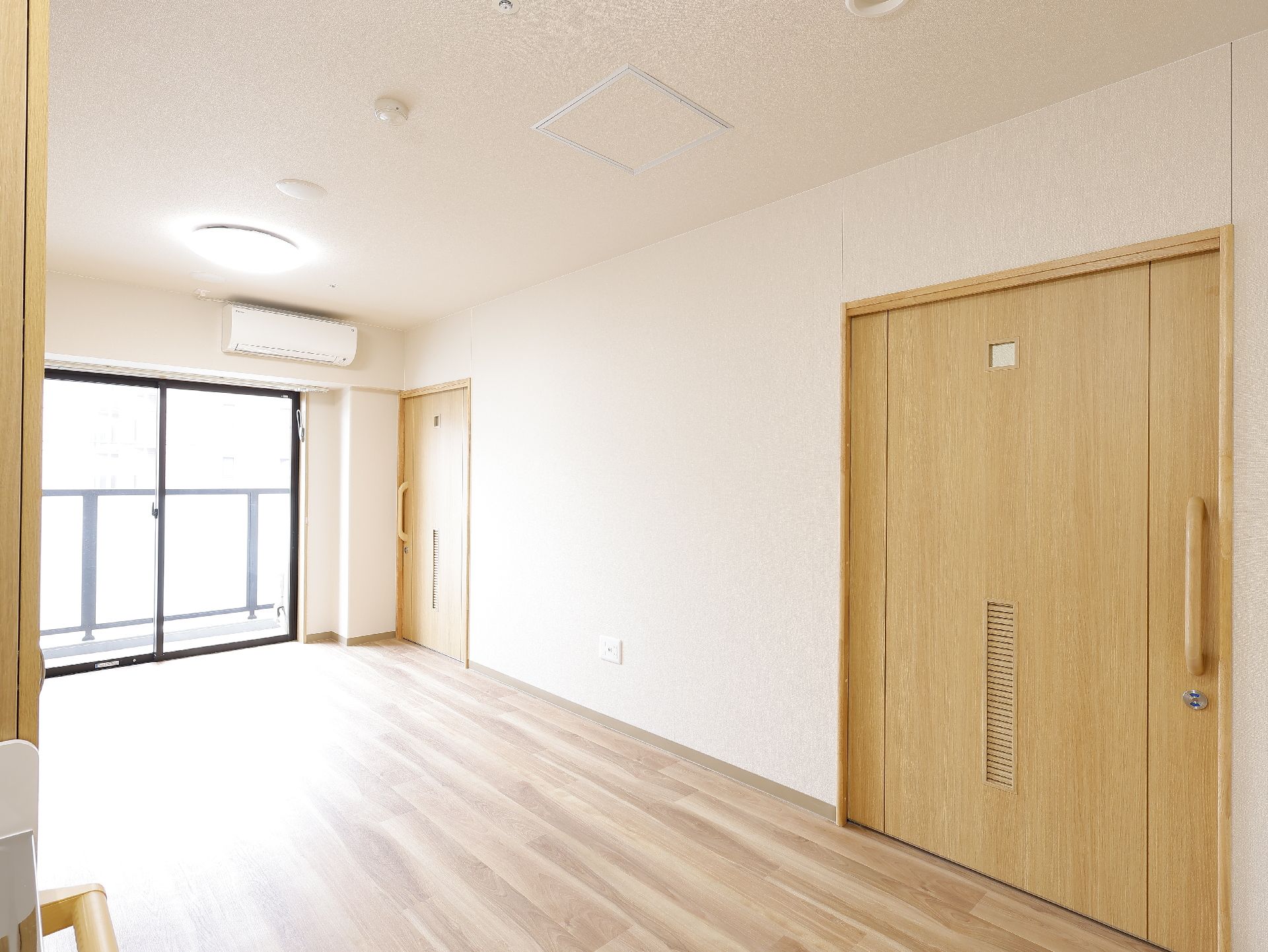 ガラス戸から陽光が入り、介護ベッドや家具を置く場所を十分に確保できる居室