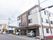 ３階建てで、白と明るい茶色の落ち着いた色合いが特徴の施設の外観