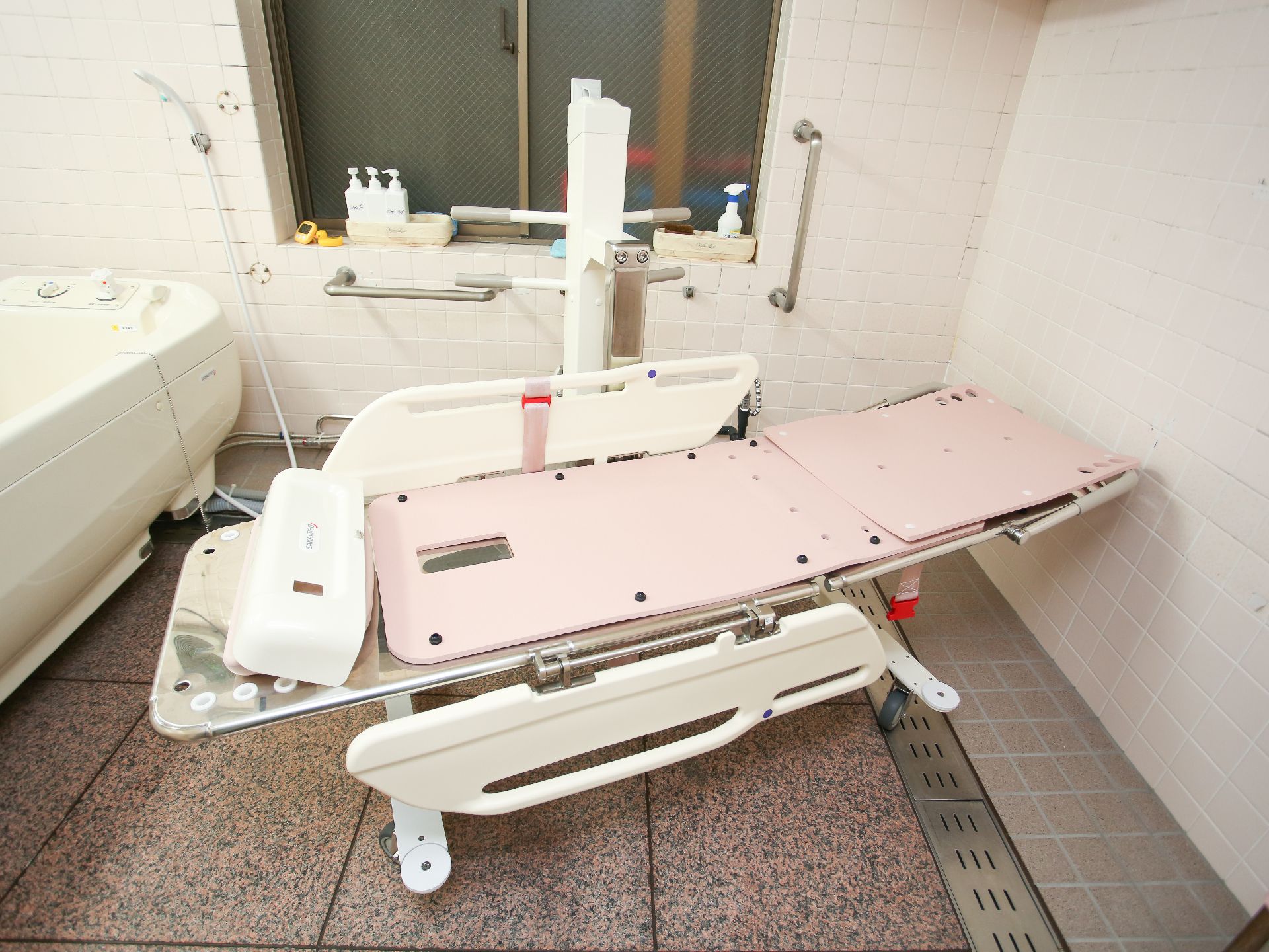 バリアフリー完備で手すりが取り付けられ、滑りにくい床材が使われている浴室