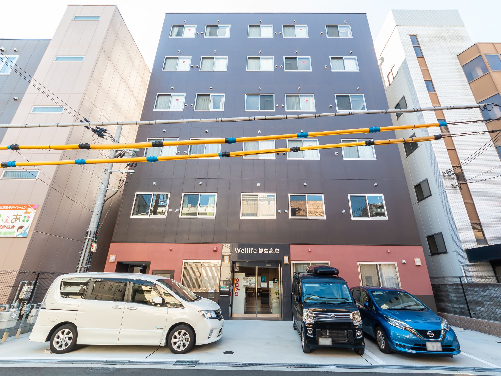 駐車場の出入り口から見た、斜め前から見た施設全体の外観