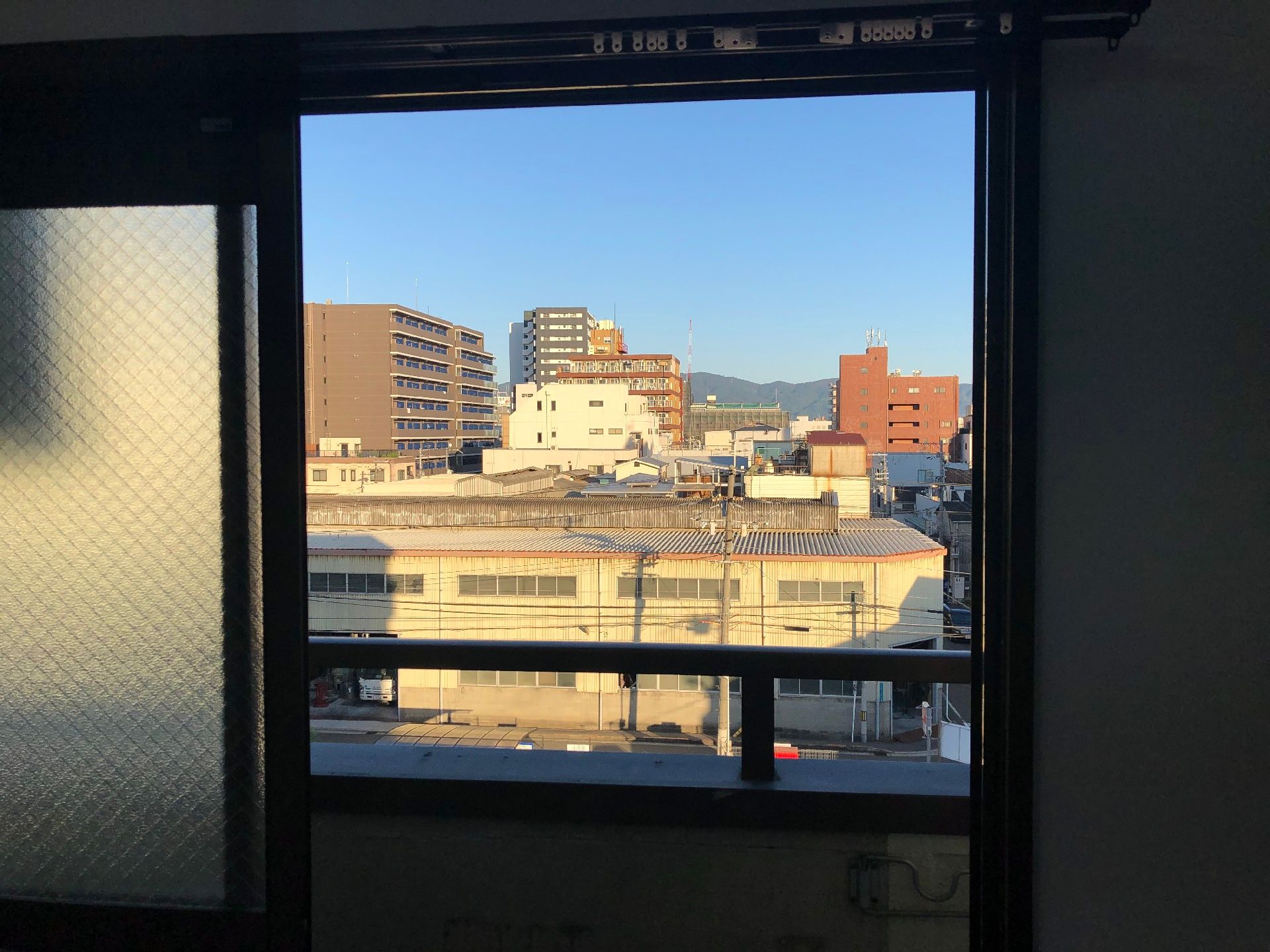 ブラウンのベストを着た車いすの高齢男性背の高い白いゆったりとした服を着た高齢女性が笑顔で話している。