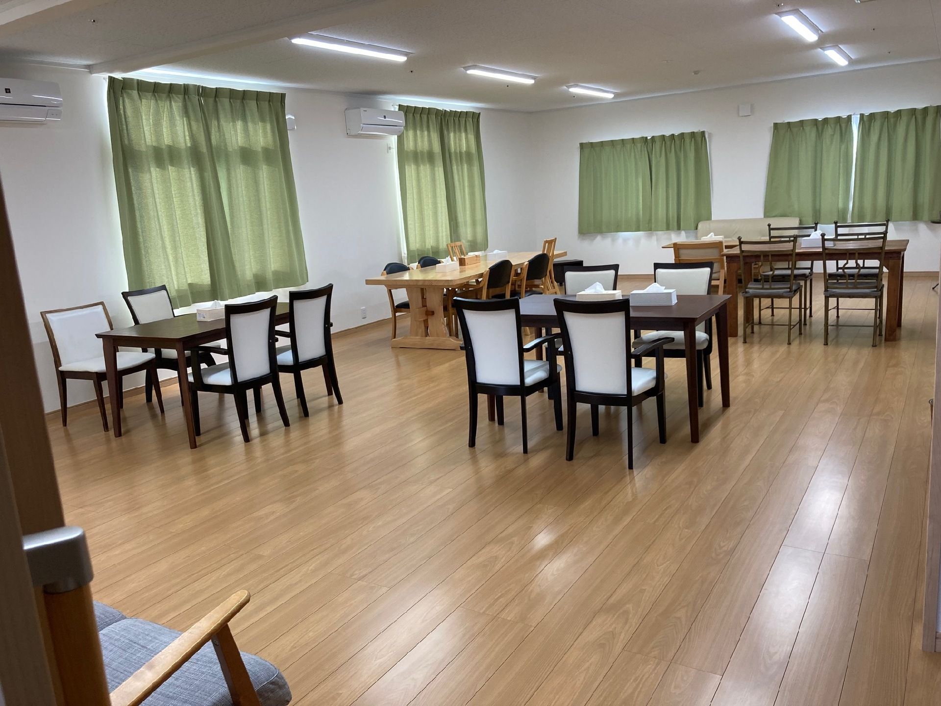 車いすに乗った女性を押す家族の男性とそこに寄り添う介護スタッフの様子