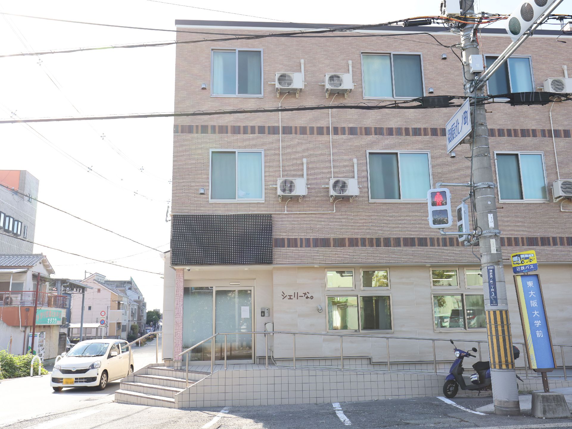 駐車場と手すりが設置してある介護施設の外観