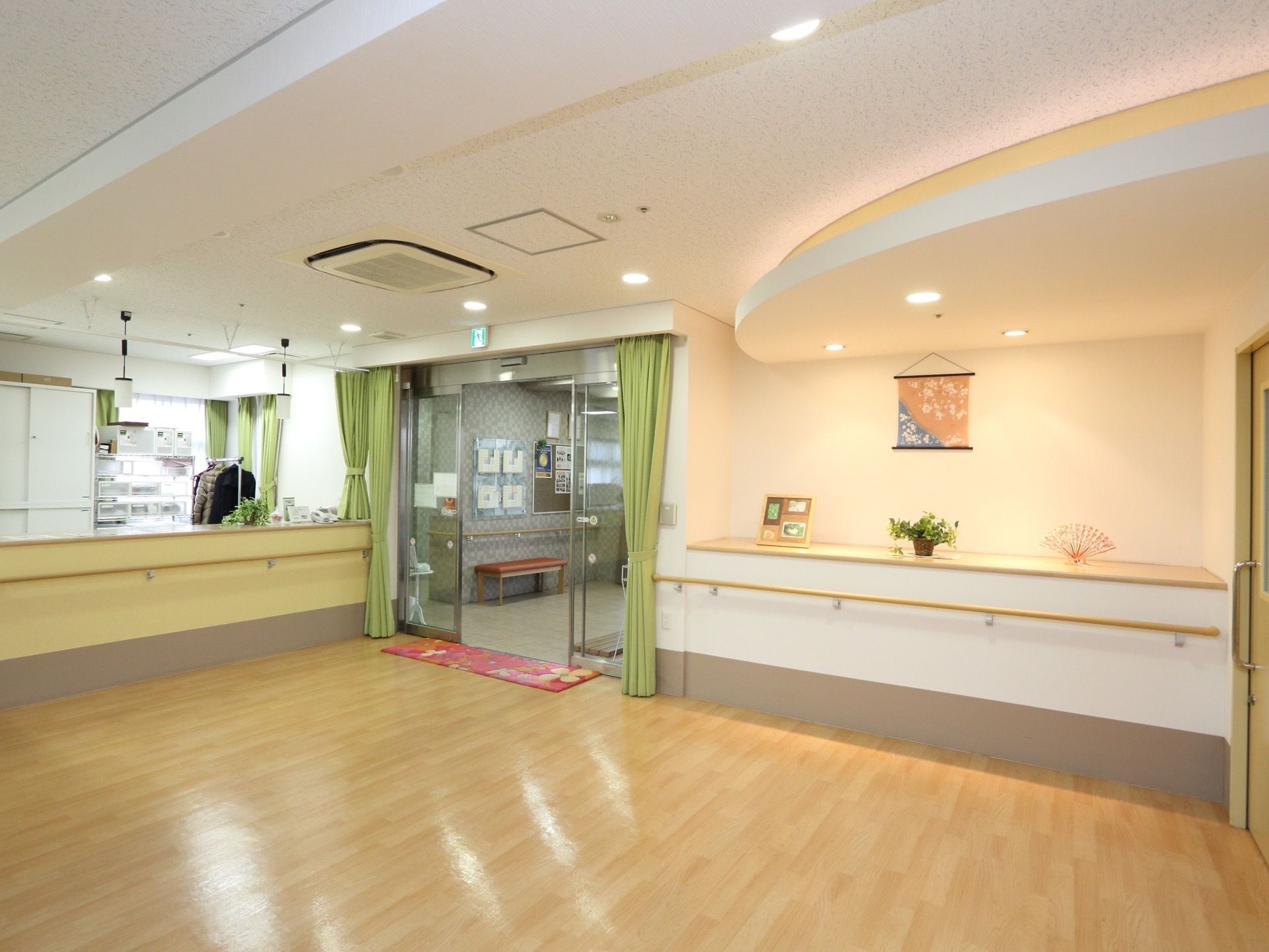 明るくすっきりとした設計の広々としたエントランスである。受付があり、手すりやベンチ、エアコンが完備されている。