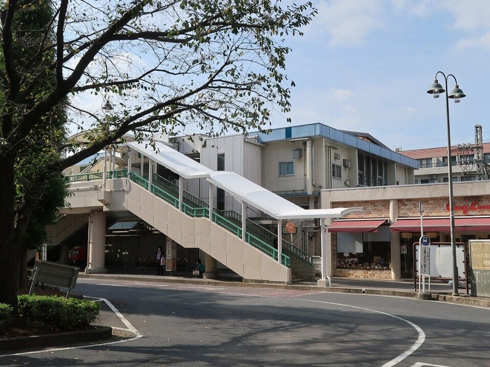 ローターリーが付いた駅は屋根付きの階段でホームに上り下りする設計。そばには大きな木がある。