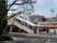 屋根付きの階段が設置された駅の前にはロータリーがあり、店舗のようなものも右側にある。