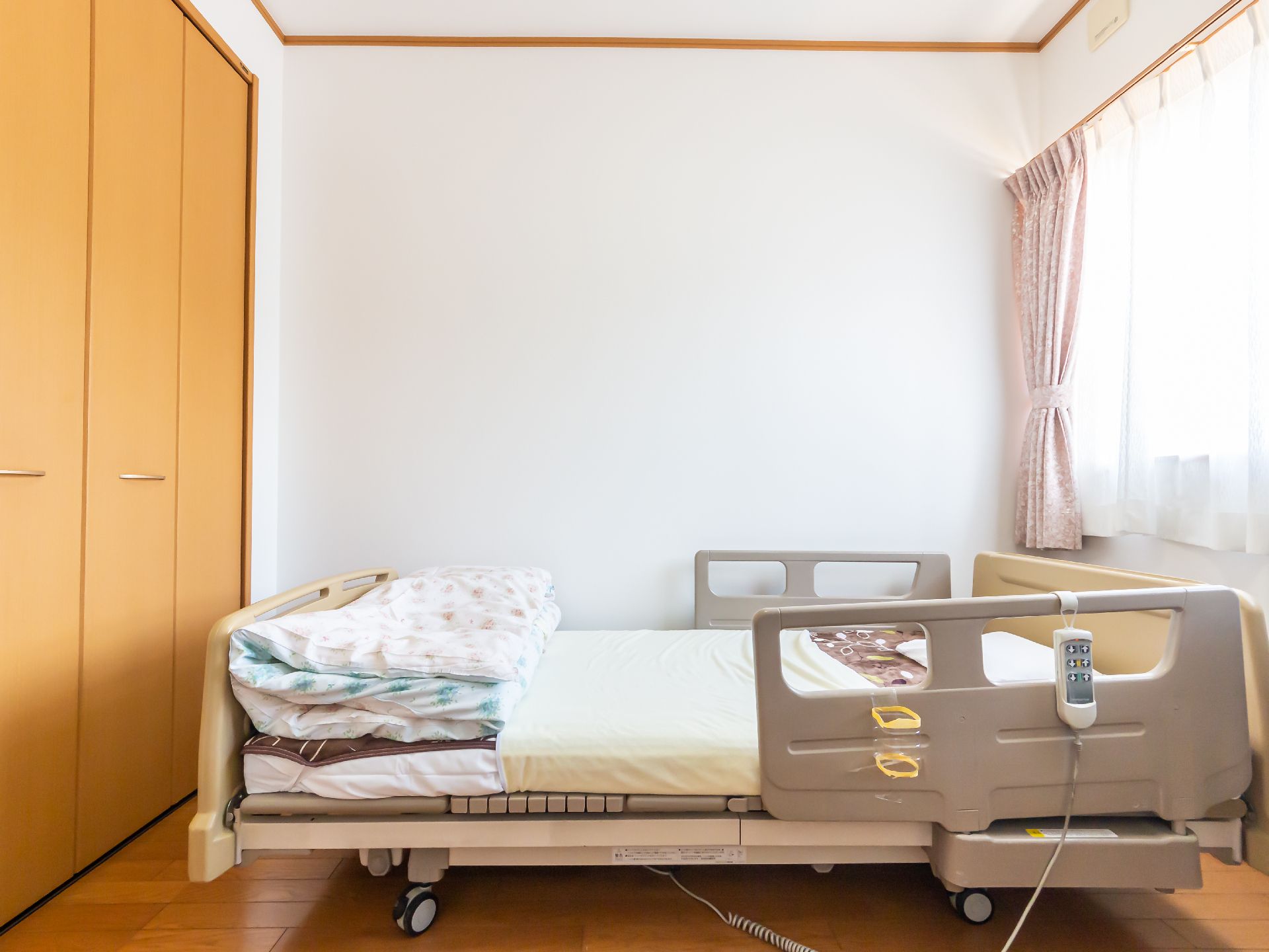 日差しが差し込み、介護ベッドが置かれている居室