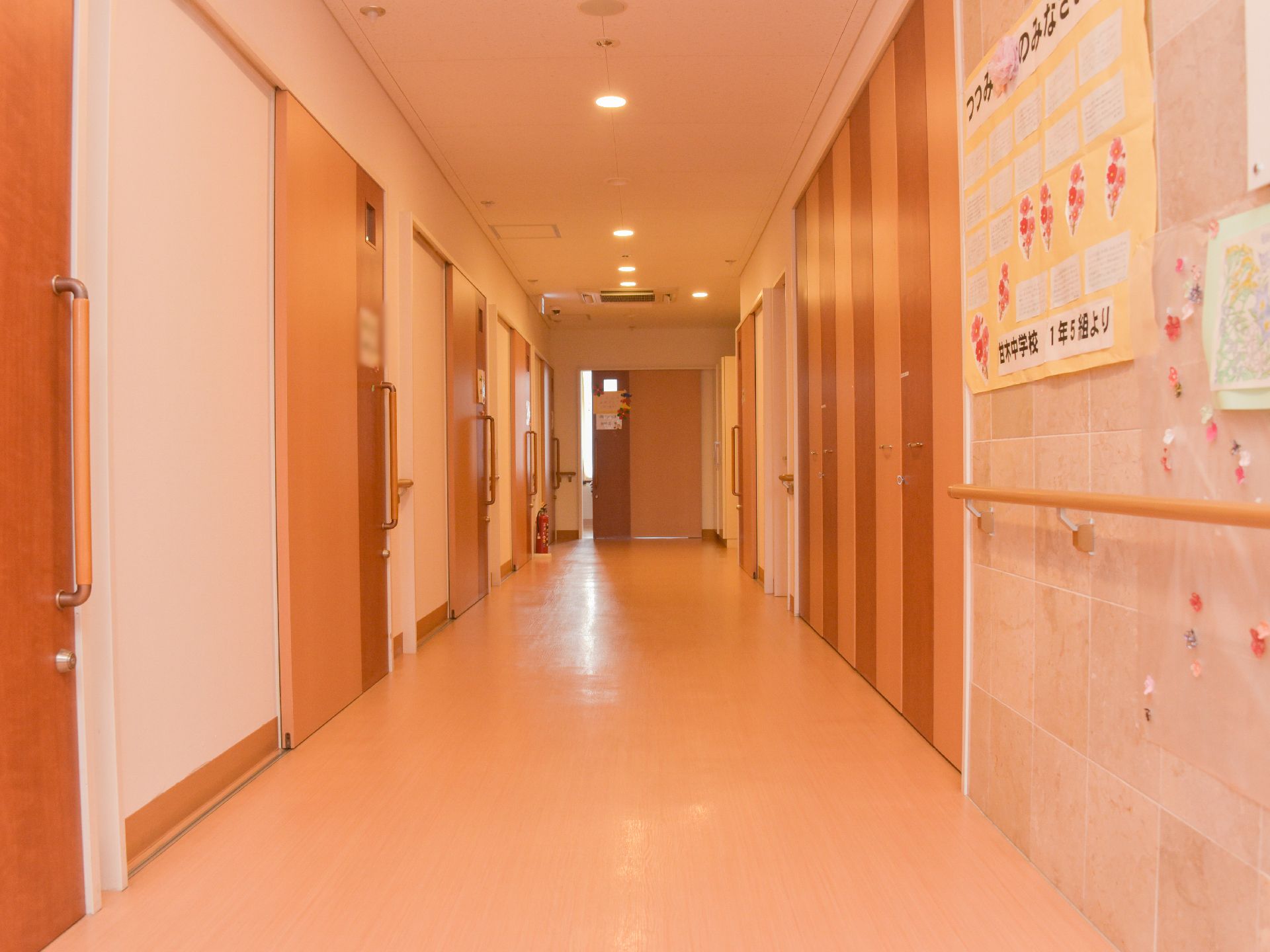 居室の扉が茶色なので、廊下は全体的に茶系統でまとまっている。居室の扉はスライド式でしっかりとしたフックが付いています。