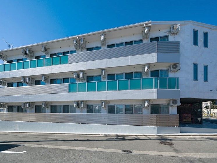 各フロアにベランダがある３階建ての建物は横に長く、日当たりのいい場所に建っている。