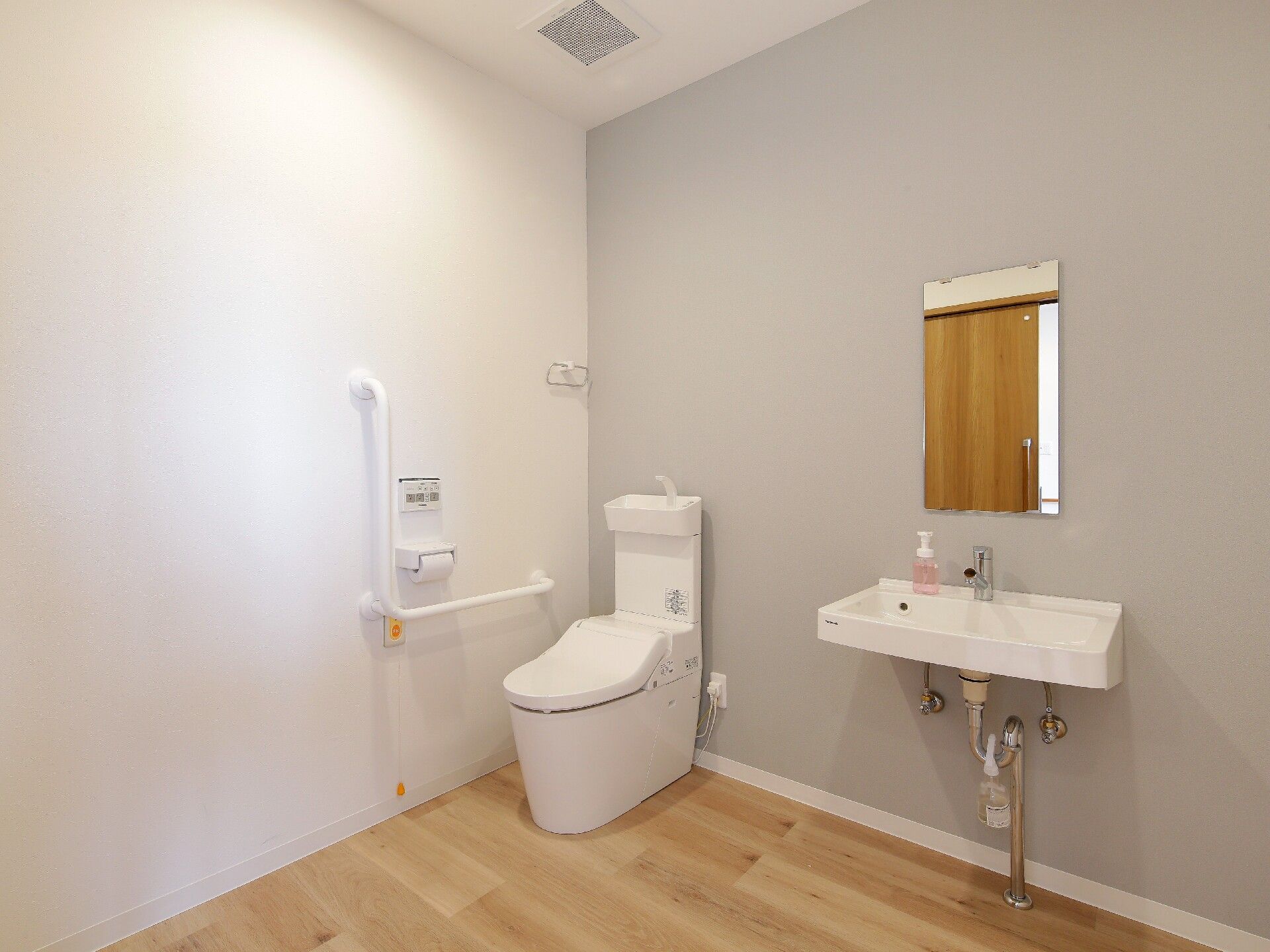 手すりと緊急コールがついた広めのトイレの様子。施設内のトイレスぺース