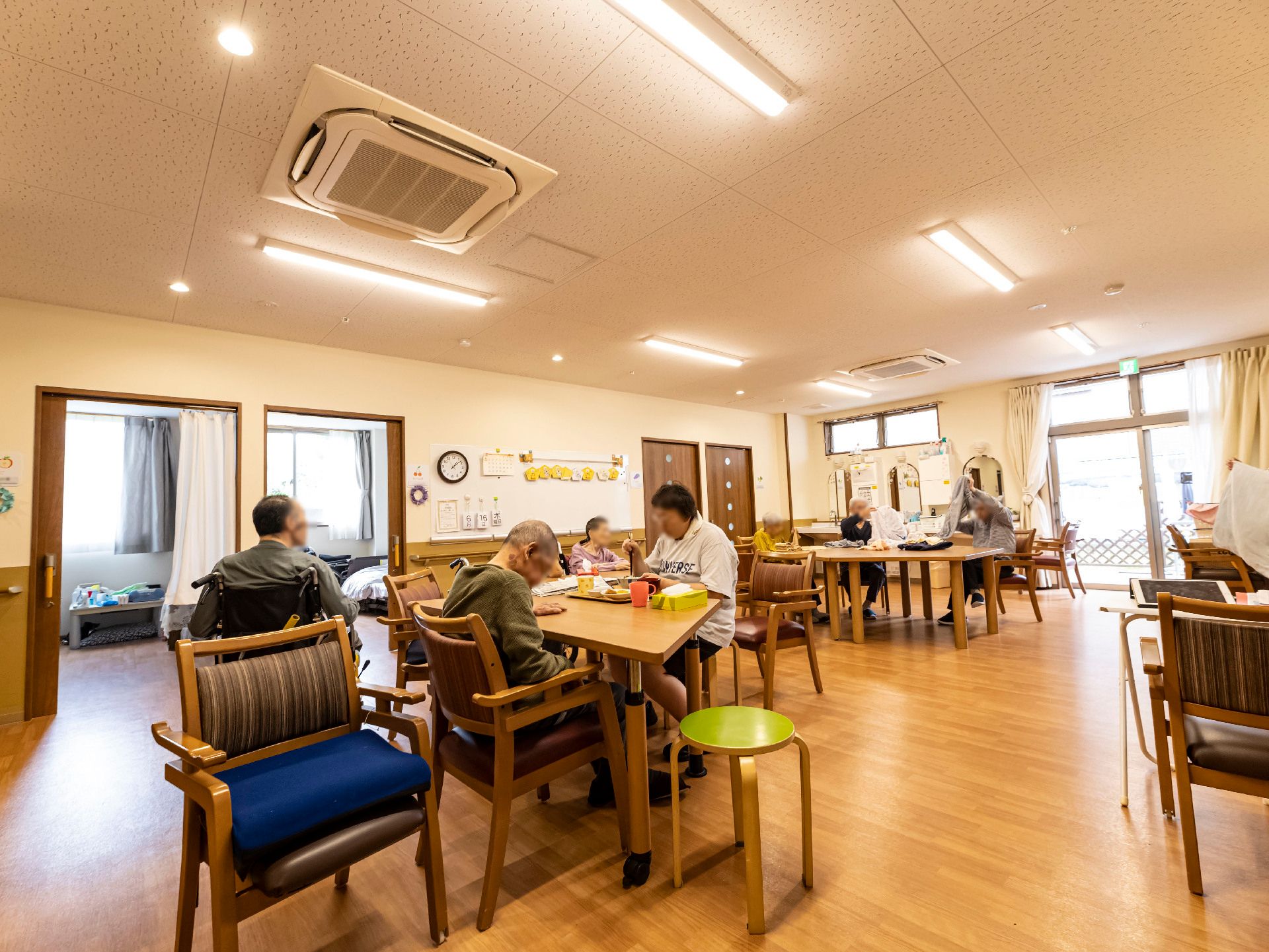 車いすの高齢者と同じ目線になって話しているスタッフとの2ショット