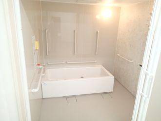 洗い場が広い浴室には一人用の浴槽が設置され、たくさんの手すりや呼び出しボタンが付いている。