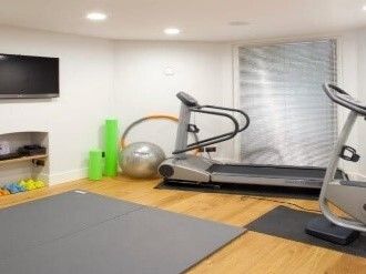 緑の多い屋外で笑顔で過ごしている車いすの高齢女性。そばにはブルーのポロシャツを着た女性スタッフがいる。