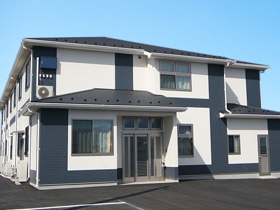 モノトーンの外壁で三角屋根の2階建て老人ホーム