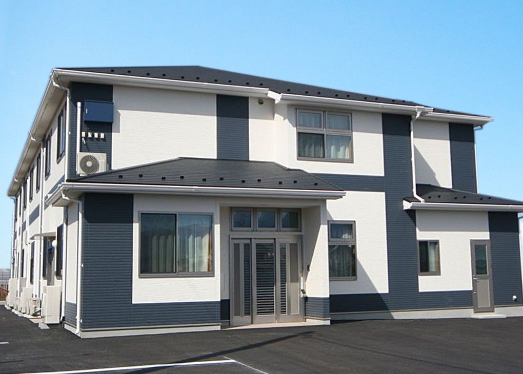 モノトーンの外壁で三角屋根の2階建て老人ホーム