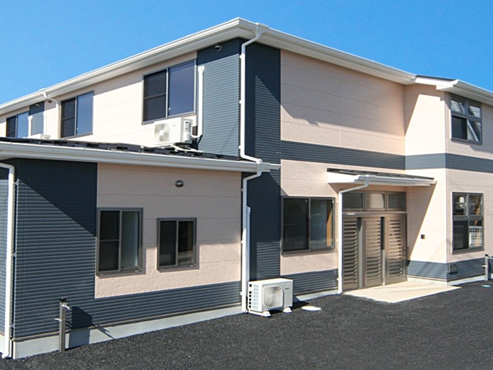 ベージュ色と黒の外壁の2階建て建築物