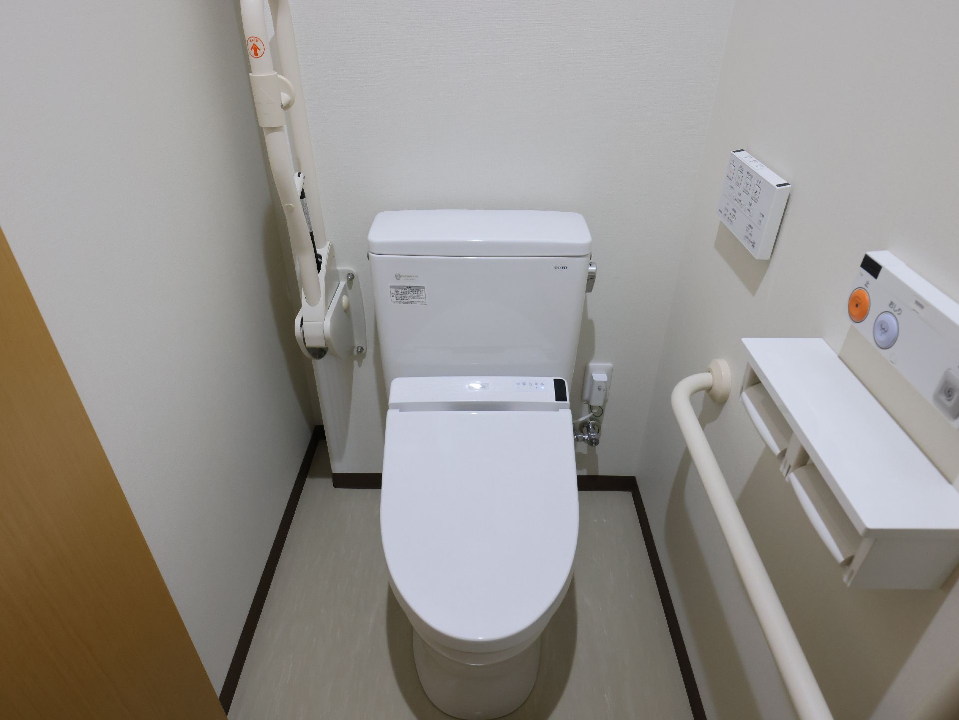 バリアフリー完備で、壁に手すりが付き、床の段差が解消されているトイレ