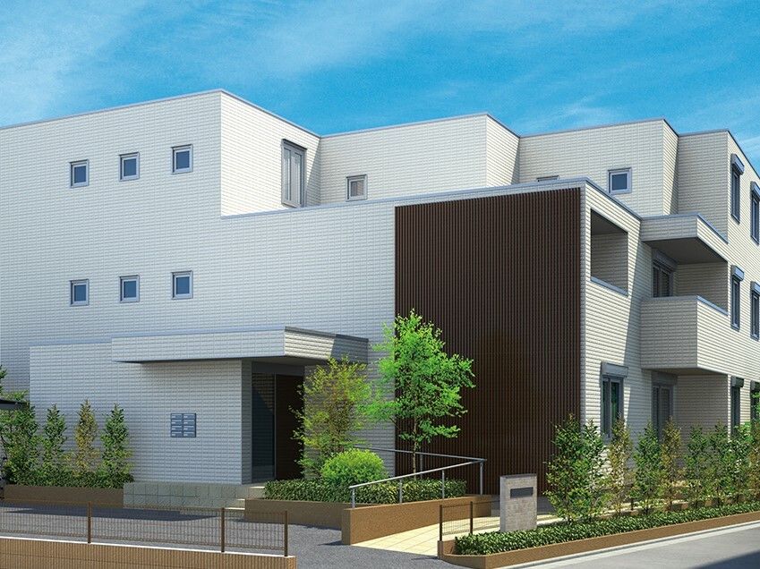 白を基調とした3階建ての建物の周りには草木が植えられ、玄関には手すり付きのスロープがあり、屋根も付いている。。