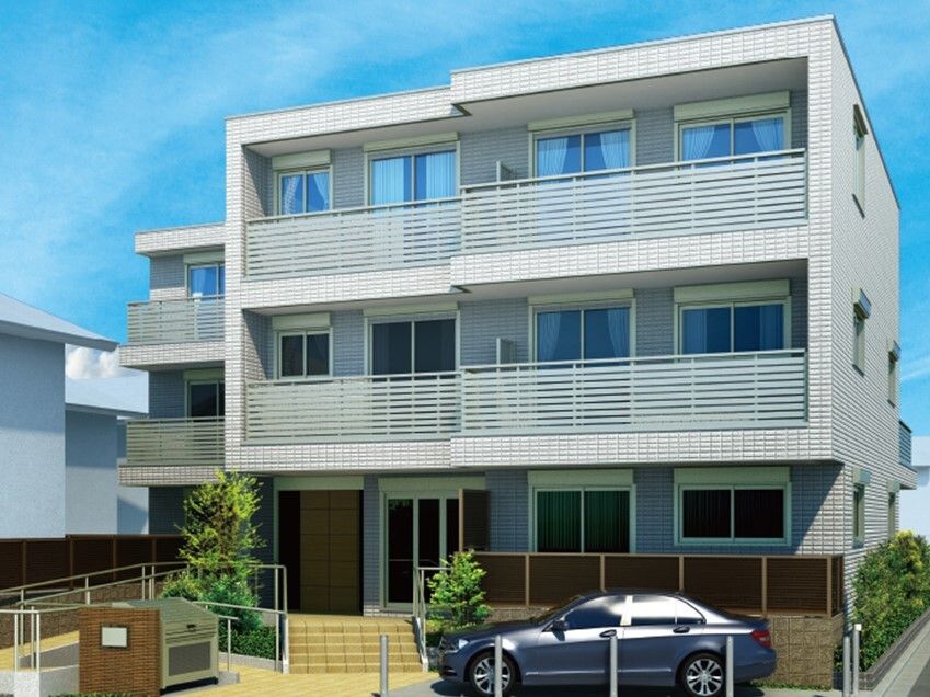 3階建ての建物はライトグレーで各フロアにベランダがあり、建物の前には駐車場があり、ゴミ捨て場もある。