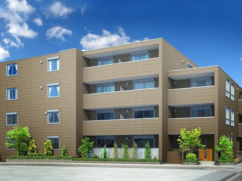 ブラウン系の4階建ての建物の周りには草木が植えられ、各フロアにベランダがあり、日当たりのいい場所にある。