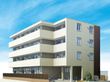 4階建ての建物は玄関には手すり付きのスロープがあり、各フロアにベランダがあり、1階部分には目隠しとなるフェンスもある。