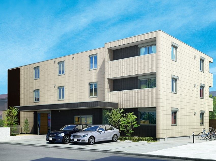 ３階建ての建物の前には駐車場があり、横には駐輪場もある。玄関には大きな屋根が付き、段差はない。