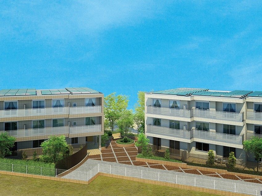 ３階建ての建物が二つ建っていて、敷地内には草木が植えられ、各フロアにベランダがある。