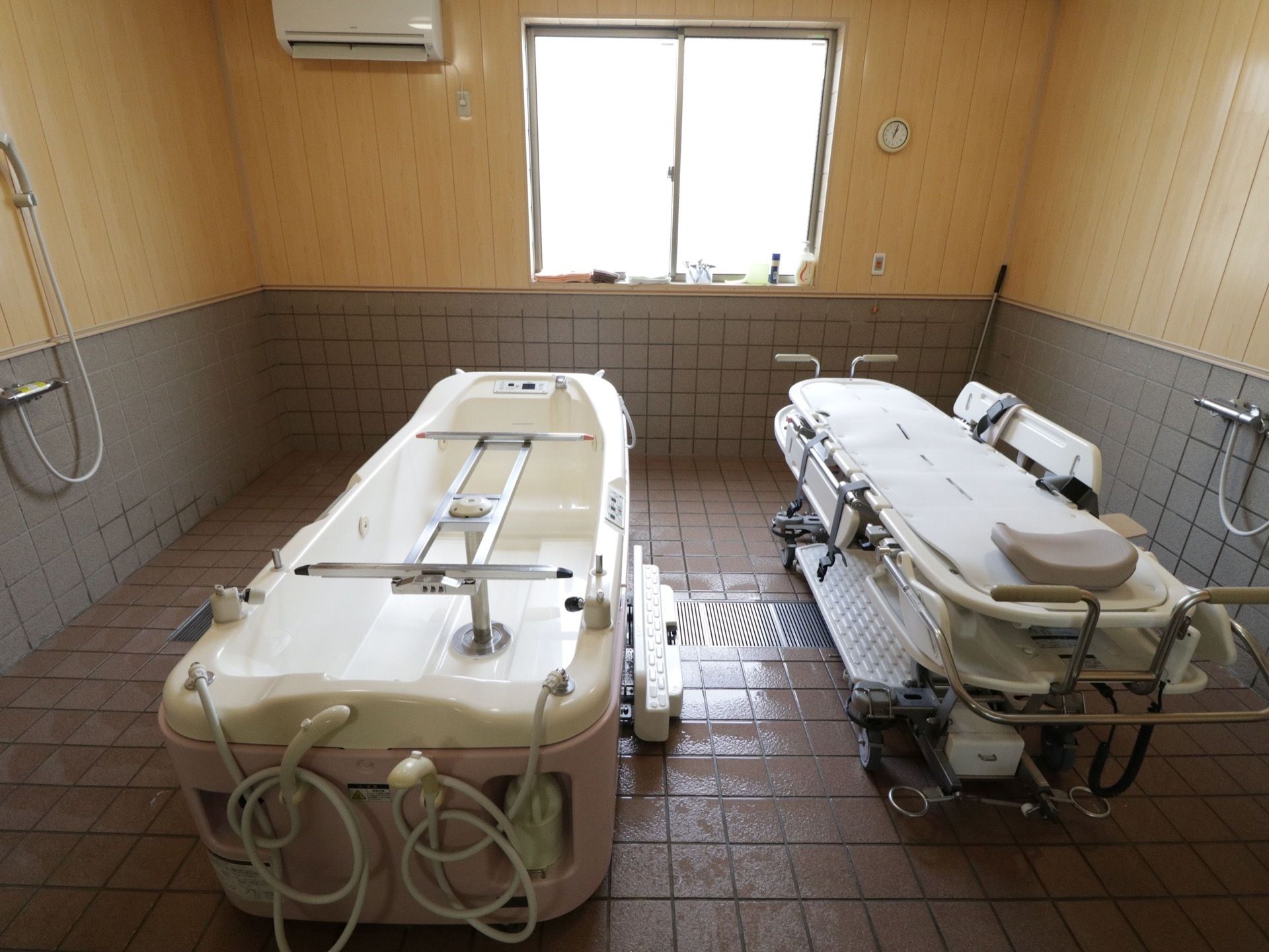 介護浴槽が完備された特殊浴室である。壁には、シャワーやエアコンが設置されている。換気に利用できる窓が設けられている。