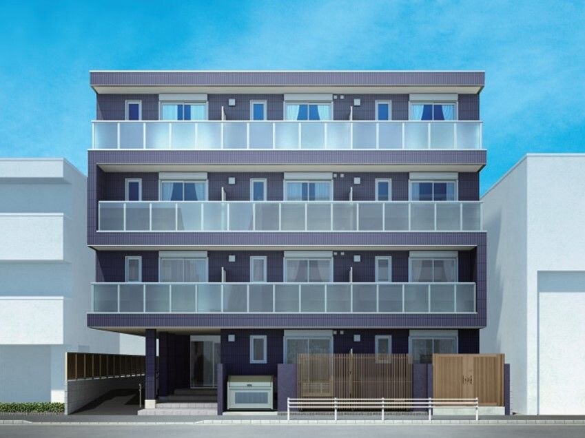 ベランダが各フロアに付いた4階建ての建物はグレー系でスタイリッシュな外観。1階部分にはフェンスもある。