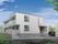 ゆるやかなスロープと階段が付いた玄関。2階建ての建物にはベランダが付き、白を基調とした清潔感のあるデザイン。