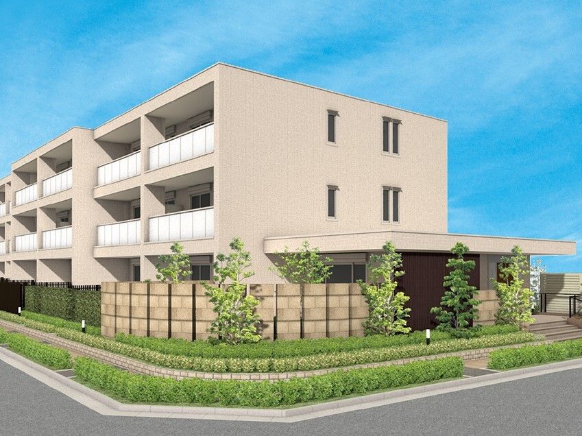 ベージュ系の3階建ての建物の周りには草木が植えられている。日当たりがよく、玄関には屋根も設置されている。