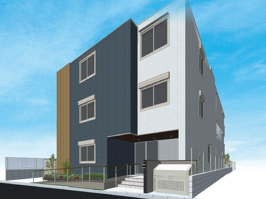 グレーやダークグレーの3階建ての建物。玄関先には階段と手すり付きのスロープが付き、草木も植えられている。