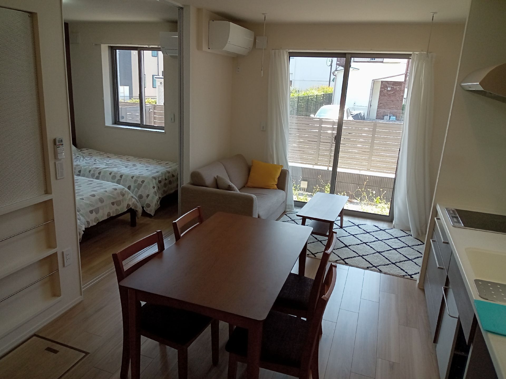 ピンクのポロシャツを着た女性スタッフと高齢女性が一緒に笑っている。高齢女性は鏡を見ている。