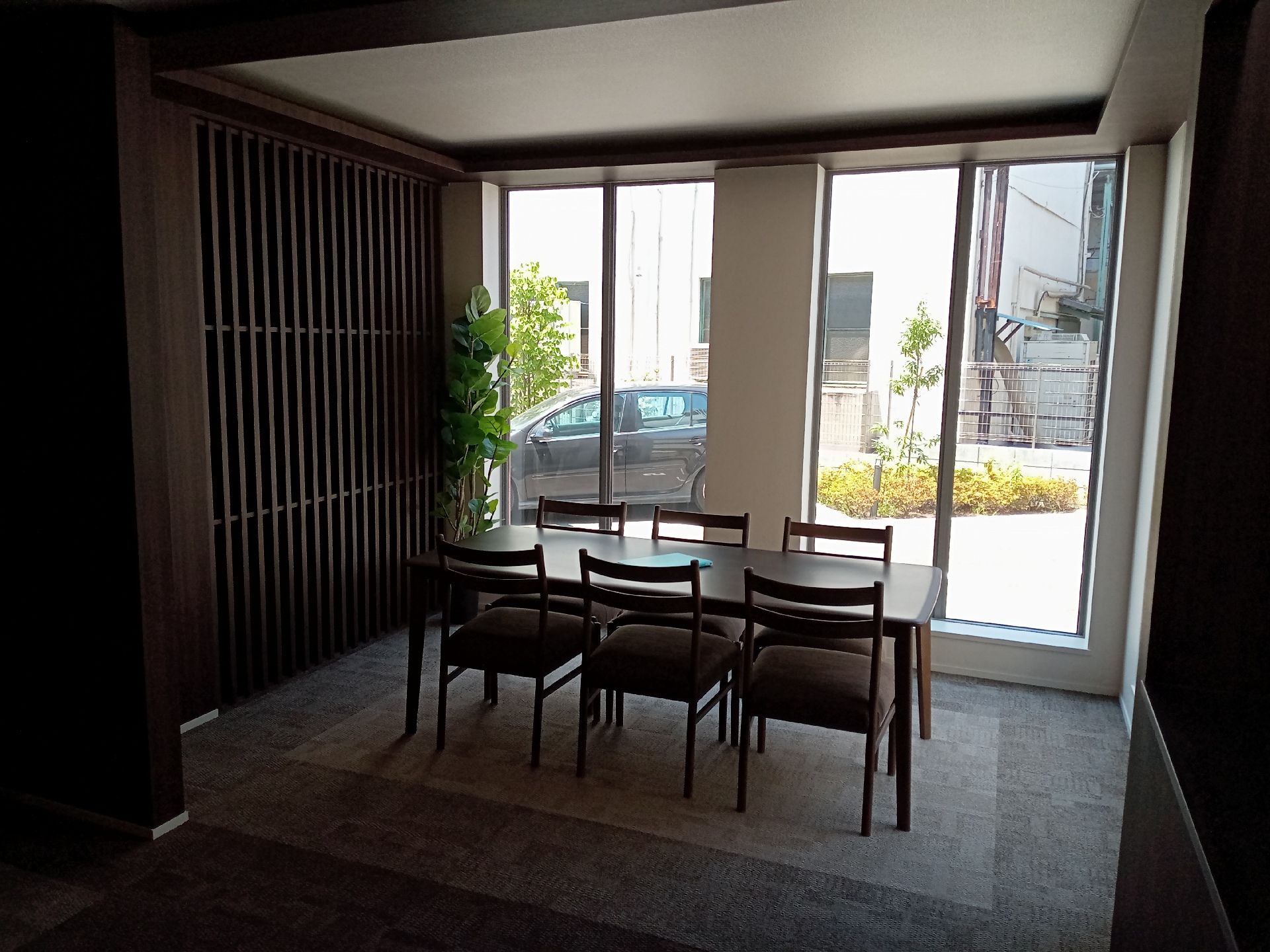 ストライプ柄のシャツを着た高齢男性のサポートに笑顔で当たっている若いスタッフ。